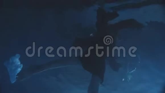 下到水里一个女人穿着黑色的裙子游泳试图从水里出来视频的预览图