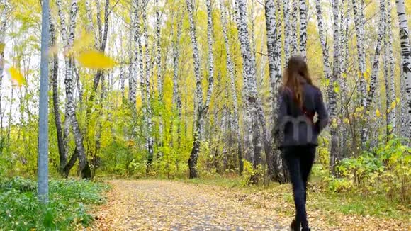 穿外套的女孩消失在黄色的公园轨道上视频的预览图
