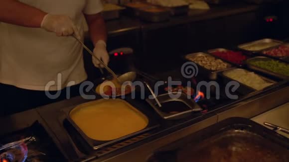 厨师在煎蛋卷中加入鸡蛋混合物视频的预览图