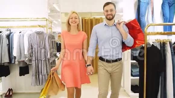 年轻的幸福夫妇在时装店一起购物慢动作视频的预览图