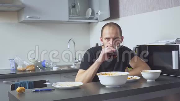 可怜的男人在桌旁吃意大利面他厨房里的家他担心是因为他的问题视频的预览图
