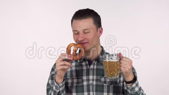 开朗的年轻人拿着一杯啤酒闻着美味的椒卷饼视频的预览图