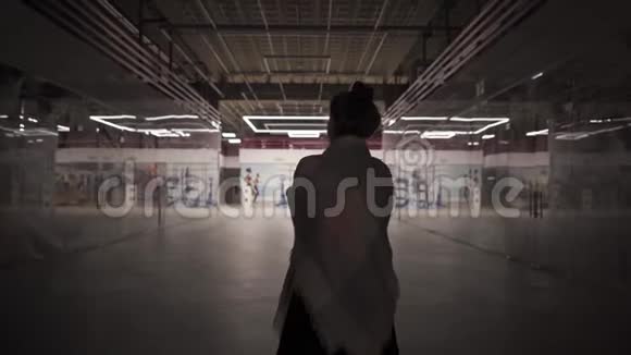 年轻的美女独自走在一个封闭的购物中心视频的预览图