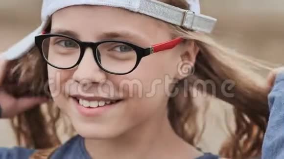 一个戴眼镜戴帽子的十一岁金发女孩的肖像面对特写镜头视频的预览图