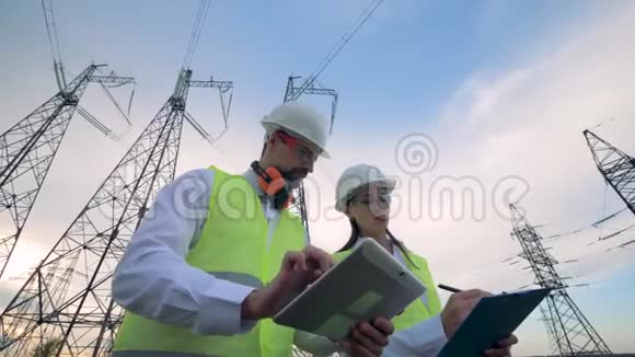 工程师讨论他们在输电线路上的工作专业电工讨论施工方案视频的预览图