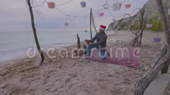 一个在海上戴圣诞帽的人打开一瓶香槟视频的预览图