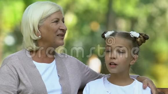 奶奶和孙女坐在公园里开心地聊天一家人视频的预览图