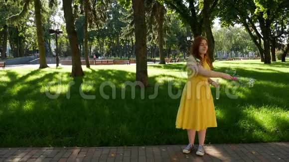 红发女孩在公园里吹肥皂泡视频的预览图