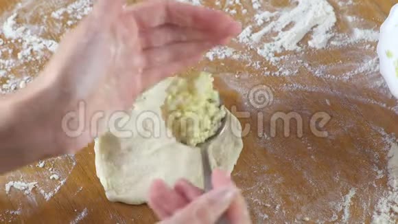 女人的手厨房桌子上用酵母面团做一个米饭和鸡蛋的馅饼特写镜头视频的预览图