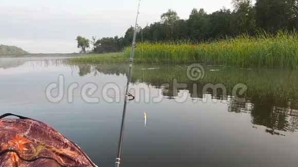 一个人在河上的充气船上钓鱼夏天人们坐着充气皮艇在河边休息视频的预览图