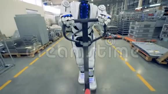 一个类似人类的机器人正在和一个工厂工人一起行走时拉着一个工厂的运输工视频的预览图