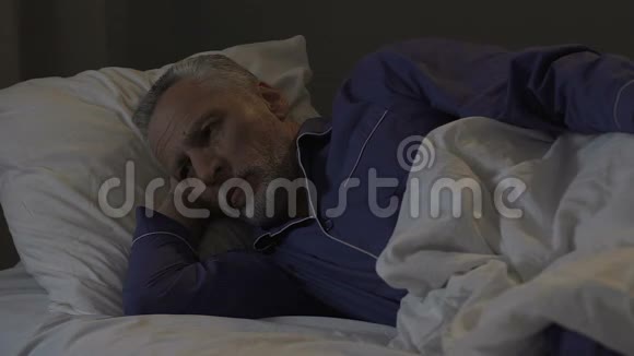 一位老人晚上躺在床上睡不着失眠思绪混乱视频的预览图