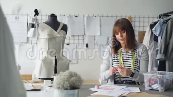 年轻的女裁缝正忙着挑选素描上新衣服的颜色她从盒子里挑选不同的筒管视频的预览图