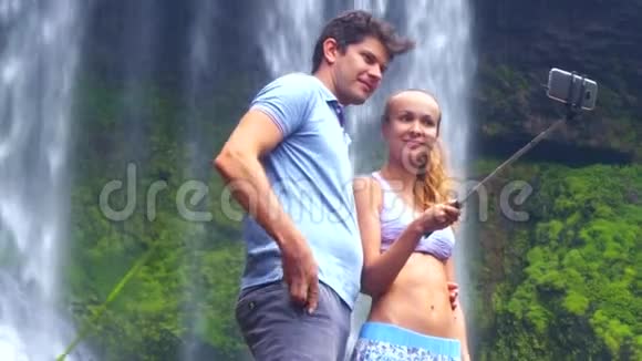 一个男女孩摆出姿势对着泡沫瀑布自拍视频的预览图