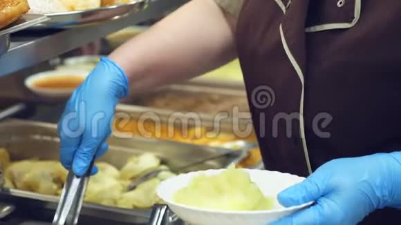 特写食堂工作人员将一部分土豆泥放在盘子上现代食堂食堂餐厅视频的预览图