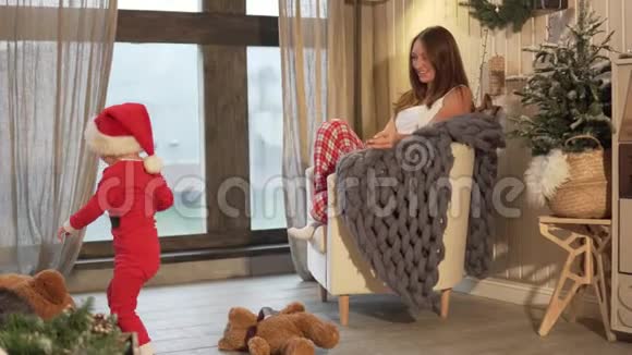 新年妈妈坐在椅子上她穿着圣诞睡衣视频的预览图