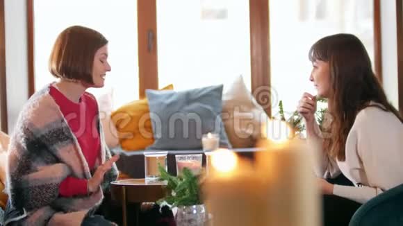 两个年轻的女人坐在咖啡馆里等待他们的命令视频的预览图