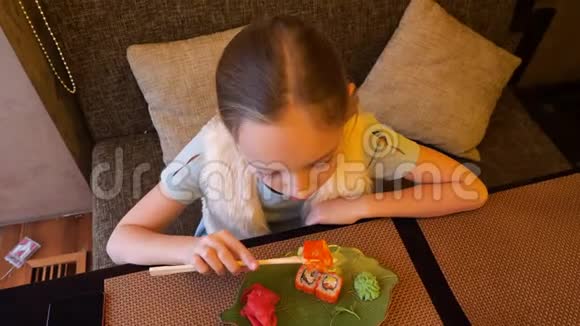 日本寿司店的顶楼女孩用筷子吃寿司卷视频的预览图