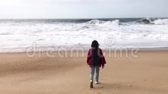 一个背着背包的年轻走在海边视频的预览图