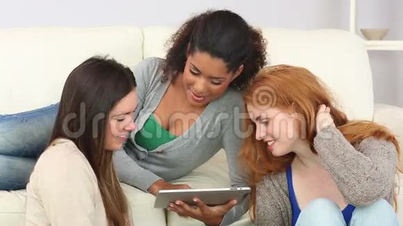 女人给她的朋友们展示她的平板电脑视频的预览图