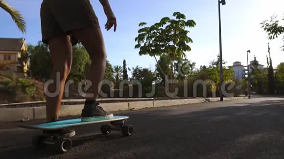 慢动作女孩在公园里用棕榈树骑滑板视频的预览图
