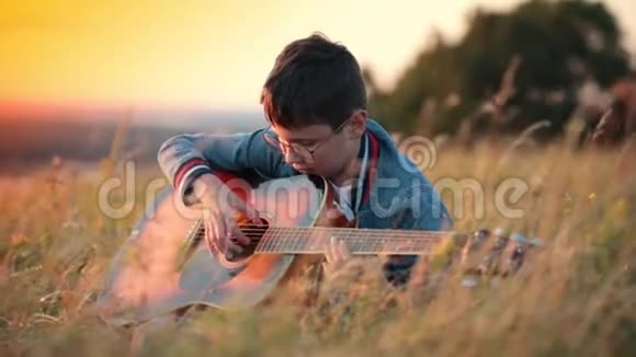 戴圆眼镜的小男孩弹吉他视频的预览图