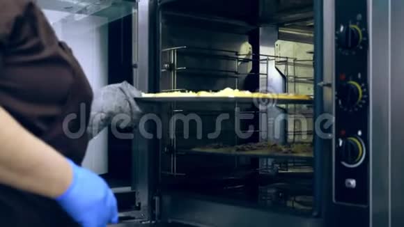 最后厨师把一个大的工业烤箱一个带面包的烤盘一个用酵母面团做的比萨饼烘烤视频的预览图