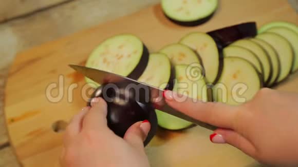 女手在木板上用刀切中茄子视频的预览图