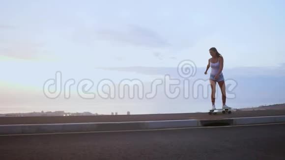 女滑板运动员骑在靠山的斜坡上的木板上视频的预览图