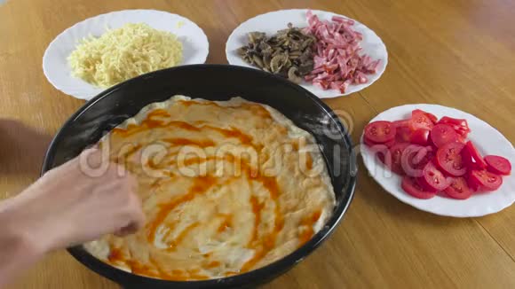 做披萨女人手做自制披萨在面团上涂抹番茄酱视频的预览图