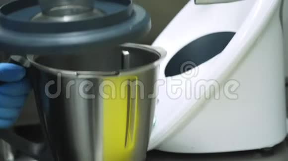 食堂商业厨房特写镜头戴手套的厨师使用一种特殊的家用电器一种工业搅拌机用于视频的预览图