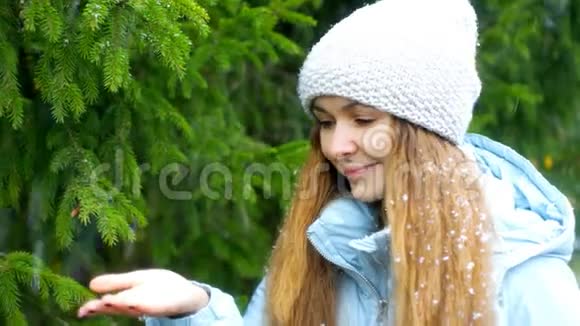第一次雪花落在金发女郎的身上她的手握着毛皮树视频的预览图