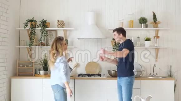 现代厨房里一个金发姑娘在桌炉旁跳舞视频的预览图
