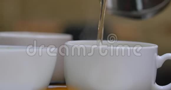 壶中的茶慢慢地倒入瓷杯中视频的预览图