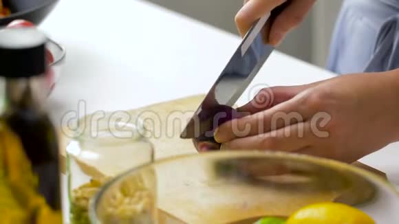 年轻女子切红洋葱做蔬菜沙拉视频的预览图