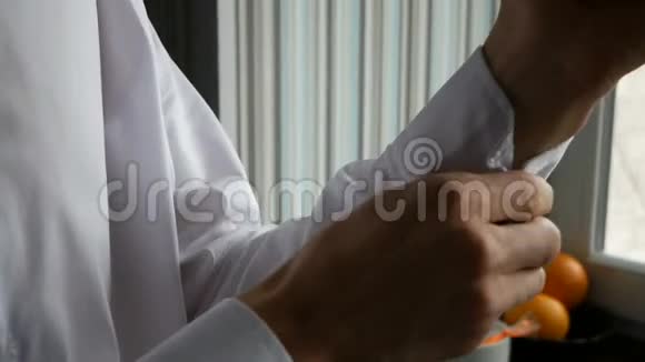 男人在衬衫袖子上扣上一个扣子视频的预览图