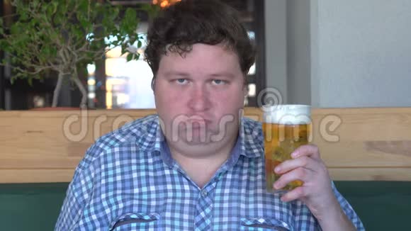 英俊的胖子拿着一杯啤酒用头答应了视频的预览图