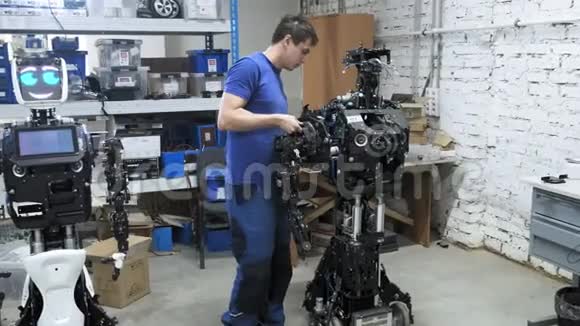 生产机器人的工厂工程师把手的另一部分贴在新机器人的身体上视频的预览图