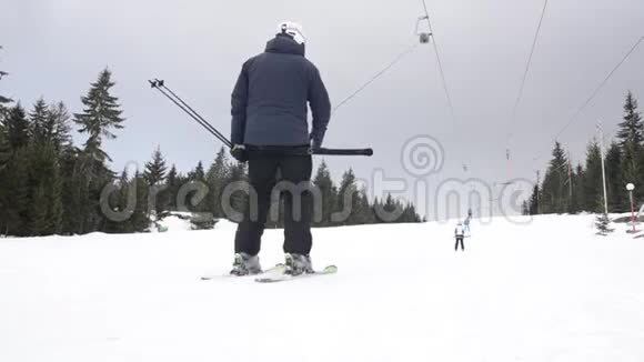 滑雪者在山上使用滑雪升降机锚人们在雪覆盖的景观上缓慢地上坡移动冬季运动视频的预览图