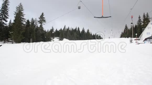 滑雪者在山上使用滑雪升降机锚人们在雪覆盖的景观上缓慢地上坡移动冬季运动视频的预览图
