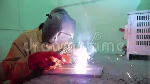 焊接面罩的焊工坐在一个特殊的房间里焊接金属结构视频的预览图