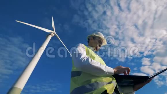 一位工程师站在风力涡轮机的背景上替代能源概念视频的预览图