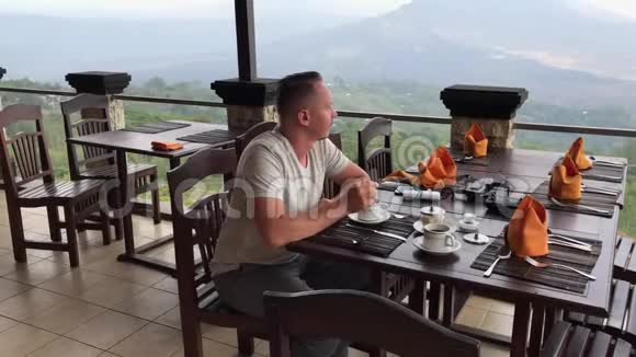 年轻人在山上喝咖啡巴厘岛巴图尔火山印度尼西亚视频的预览图