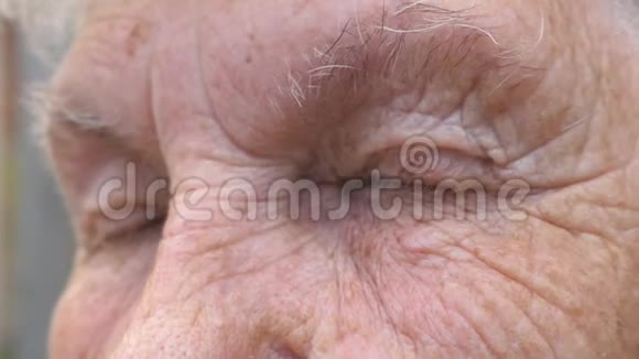 闭上灰色眼睛的老年妇女与皱纹周围祖母带着悲伤看镜头的肖像视频的预览图