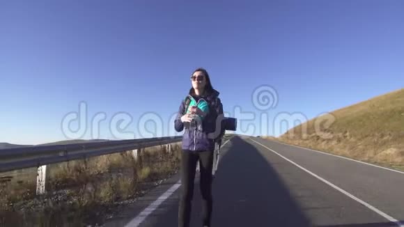 女游客背着背包在去山的路上喝水视频的预览图