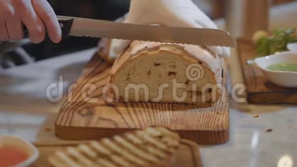 厨师双手戴着白色橡胶手套在木板上切麦面包现代食品供应视频的预览图