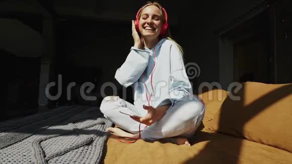 自然微笑的金发女郎在卧室听音乐视频的预览图