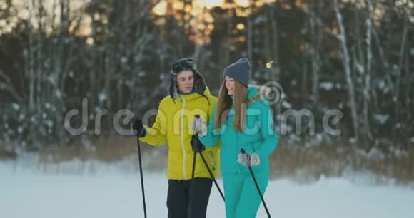 在冬季森林滑雪行走期间一个有爱心的年轻人帮助受伤的女友的完整画像视频的预览图