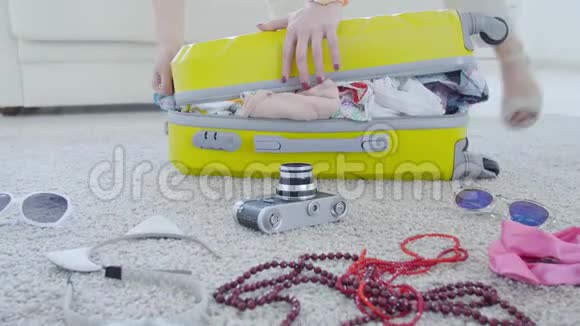 行李和旅行概念年轻女子把东西放在手提箱里度假视频的预览图