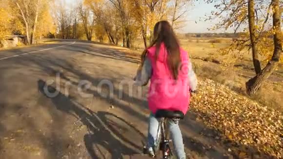 十几岁的女孩在公园里学骑自行车女孩的手拿着弯曲的车把视频的预览图